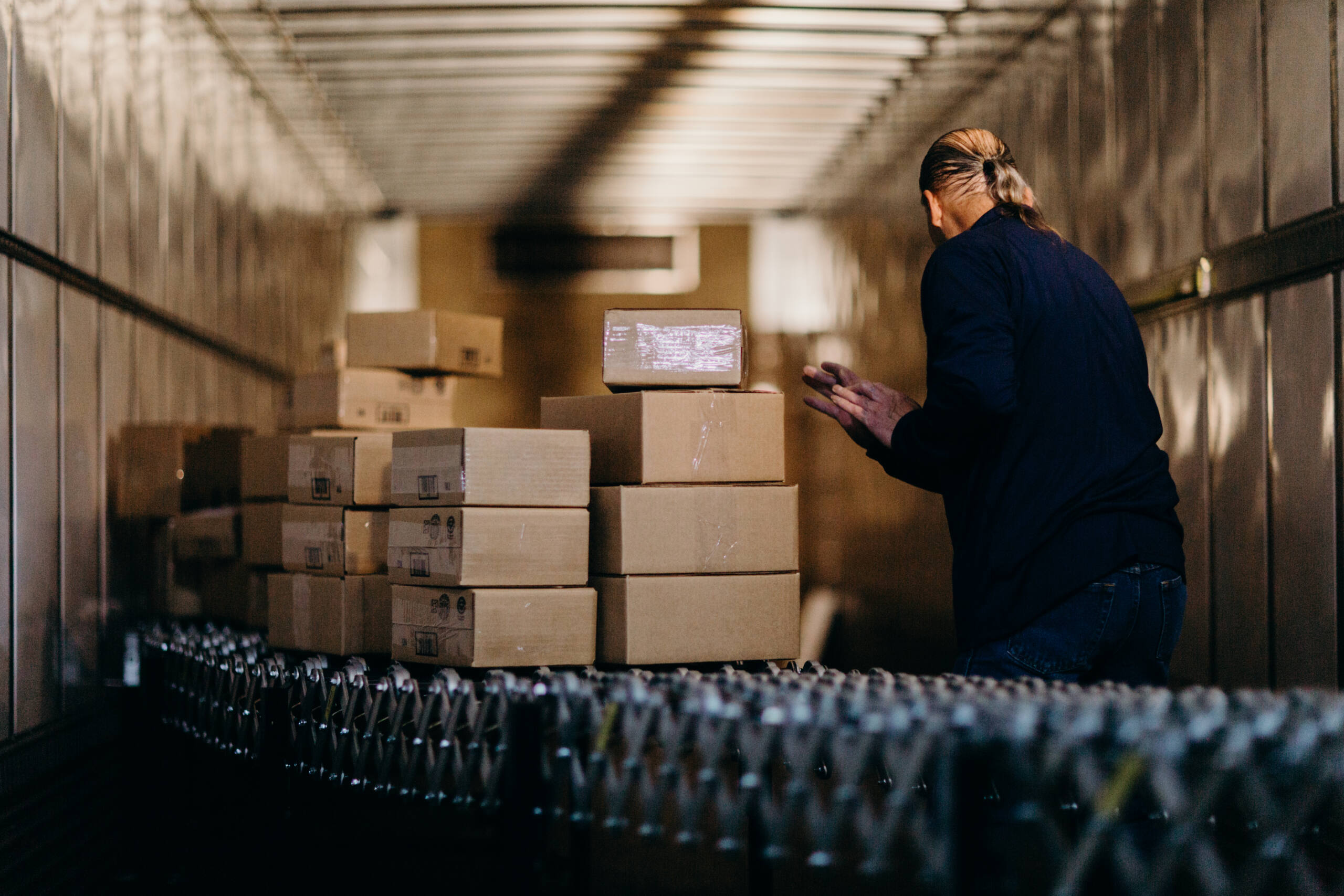 FRG is an Outdoor Goods Distributor and logistics manager. An FRG employee loads packages into a loading bay.